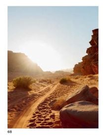 Book cover of Deserted: In Pursuit of Drylands, with an aerial view of desert landscape with sand dunes. Published by Lannoo Publishers.