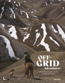 Book cover of Off-Grid Adventures: 20 Untamed Travel Stories Around the World, with a rider on horseback in remote mountain landscape, with dog walking beside. Published by Lannoo Publishers.