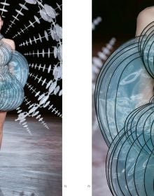 Book cover of Iris van Herpen, Sculpting the Senses, with model wearing white sculptural snake-like shoulder piece. Published by Lannoo Publishers.