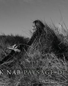 Book cover of Dirck Nab – Paysage Dessiné, with the artist sitting amongst coastal dunes. Published by Waanders Publishers.