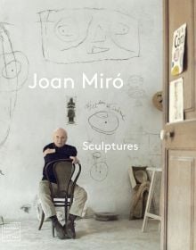 Book cover of Joan Miró: Sculptures, with the artist sitting on a chair in his studio. Published by Waanders Publishers.