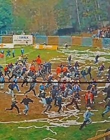 Book cover of Slash & Burn: Marcin Dudek, with a crowd of people running on a sports pitch, with paper strewn on the ground. Published by Hopper&Fuchs.