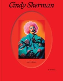 Book cover of Cindy Sherman: Anti-Fashion, with a model dresses as a clown with pink curly wig. Published by Hannibal Books.